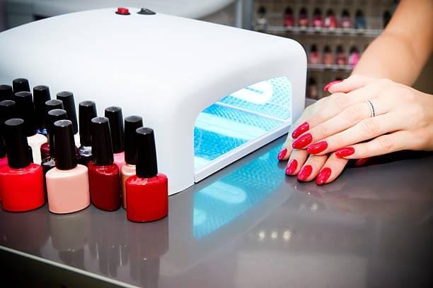 A woman at a nail salon drying her nails Manicure set in a beauty salon. Beautiful female hands. Machine for drying naroshchennyh nail UV lamp. gel polish stock pictures, royalty-free photos & images