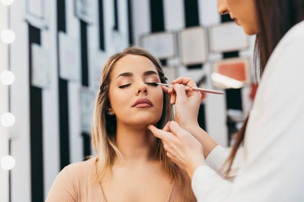 Professional makeup artist at work Professional makeup artist doing professional make up of beautiful young woman. makeup stock pictures, royalty-free photos & images