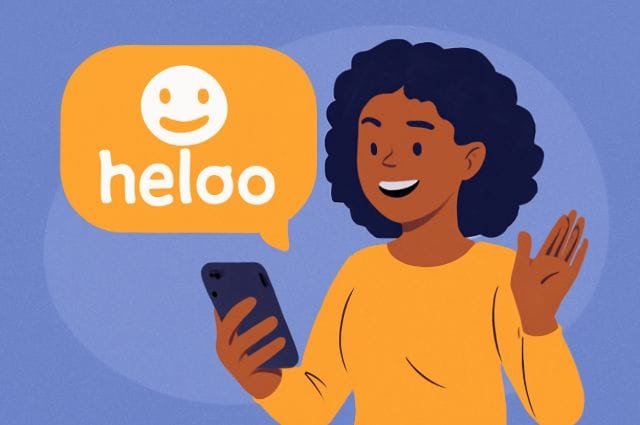 Heloo A woman smiles while using her phone to send a cheerful