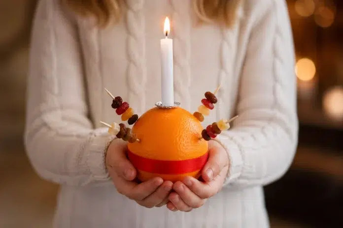 Christingle Orange with candle, red ribbon, and sweets in a Christmas church service